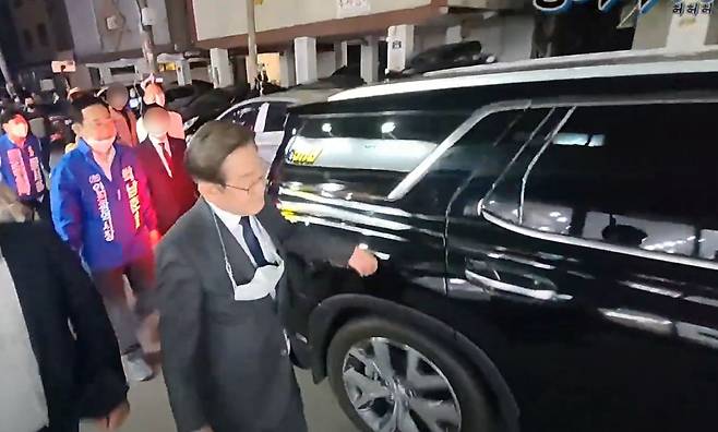 인천 계양을 보궐선거에 출마한 이재명 더불어민주당 총괄선대위원장이 18일 밤 인천 계양구 거리유세 도중 자신에게 욕을하고 지나가는 한 시민의 차량을 두드리며 따라가고 있다./유튜브황기자TV 캡처
