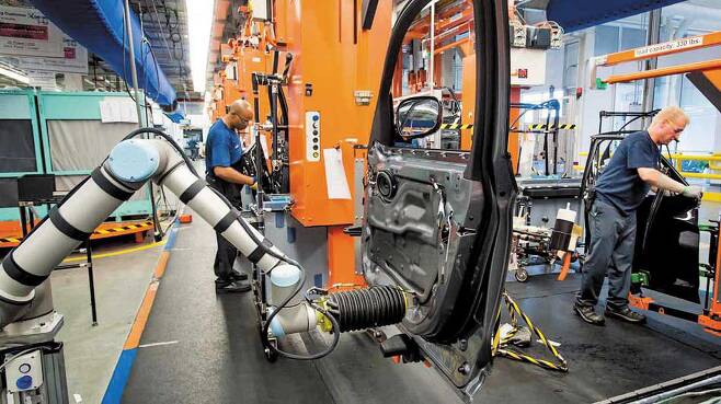 유니버설로봇이 만든 협동로봇 ‘UR10’이 자동차 제조 공장에 투입돼 근로자들과 함께 차량 조립 작업을 하고 있다. UR10은 최대 12.5㎏까지 들 수 있고, 작동 반경은 130㎝다. /유니버설로봇