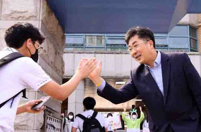 성기선 경기도교육감 후보가 19일 칠보중학교 앞에서 등교하는 학생들과 하이파이브를 하고 있다. 성기선 후보 제공