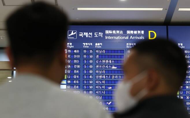 19일 인천국제공항 입국장 전광판에 적혀있는 국제선 도착시간을 보고 있는 승객들의 모습이다. 연합뉴스 제공