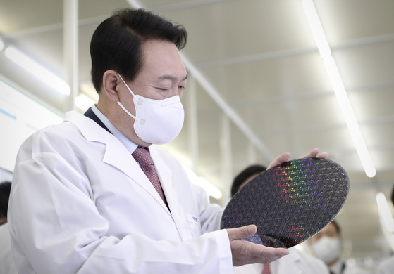 President Yoon Suk-yeol inspects a wafer during his visit to National Nanofab Center at KAIST in Dajeon, on April 29. [YONHAP]