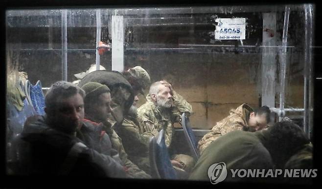 버스로 호송되는 우크라이나 아조우스탈 투항병들 (올레니우카 로이터=연합뉴스) 우크라이나 항구도시 마리우폴의 아조우스탈 제철소에서 투항한 우크라이나군 병사들이 20일(현지시간) 친(親)러시아 반군의 감시를 받으며 호송 버스를 타고 동부 도네츠크주(州) 올레니우카에 도착하고 있다. 러시아 국방부는 이 제철소에서 투항한 우크라이나 군인이 1천700명을 넘어섰다고 밝혔다. 2022.5.20 sungok@yna.co.kr