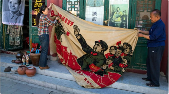 <문혁 시절의 걸개그림을 꺼내 드는 한 중년 부부. 2016년 중국의 한 도시. https://www.thequint.com/news/world/china-calls-maos-cultural-revolution-a-huge-disaster#read-more>