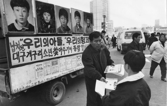 실종된 대구 성서초등교 개구리소년의 부모들이 1991년 서울역 앞에서 어린이들을 찾아달라는 내용의 전단을 행인들에게 나눠주고 있다. 중앙포토
