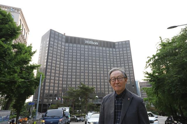 자신이 디자인한 힐튼호텔을 배경으로 서 있는 건축가 김종성.송인호 작가 제공