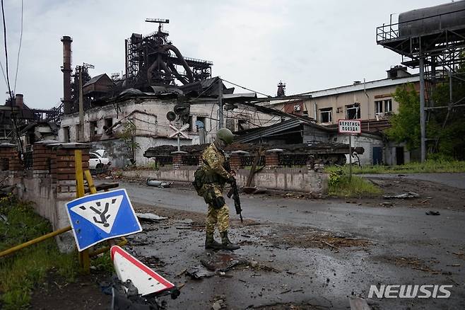 [마리우폴=AP/뉴시스]우크라이나 마리우폴에서 러시아 군인이 파괴된 일리치 제철소 부근을 순찰하고 있다. 2022.05.18.