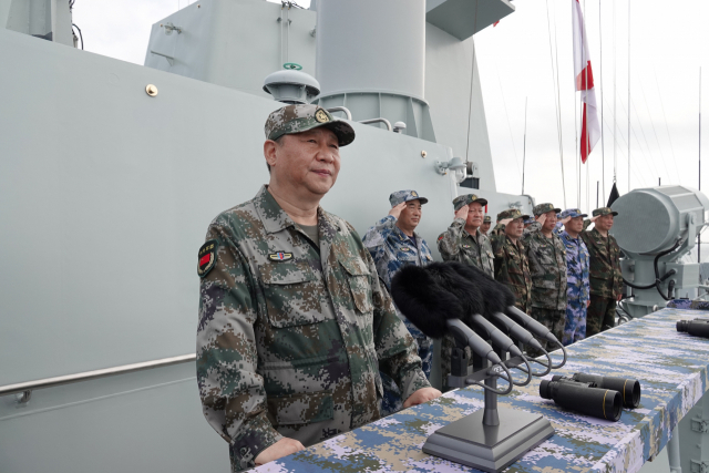 군복 차림의 시진핑 중국 국가주석(왼쪽)이 2018년 4월 중국군이 미국을 겨냥해 영토 분쟁해역인 남중국해에서 개최한 사상최대 규모의 해상열병식을 사열하고 있다. 신화연합뉴스