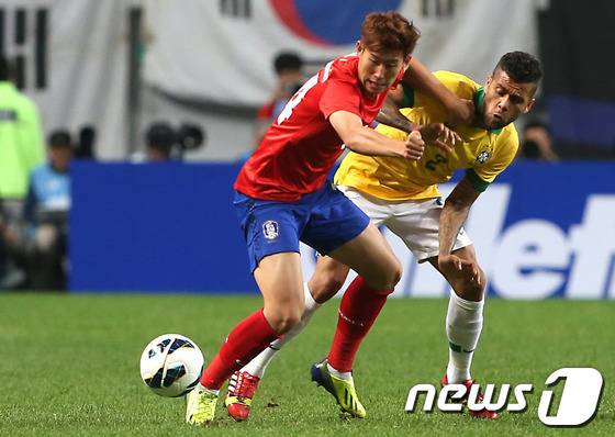 12일 오후 서울월드컵경기장에서 열린 축구 국가대표 평가전 한국과 브라질의 경기에서 손흥민과 브라질 아우베스와 공을 다투고 있다. 2013.10.12/뉴스1