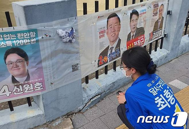 훼손된 자신의 벽보를 보고 있는 최홍린 달서구 사선거구 구 의원 후보. (최홍린 후보 페이스북 갈무리) © 뉴스1