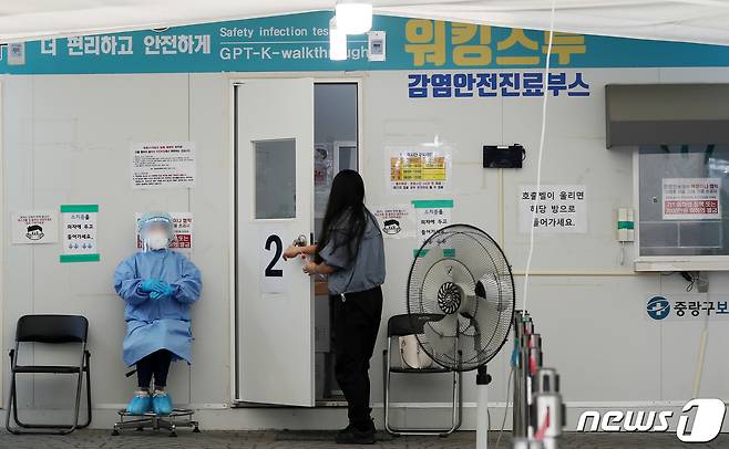 22일 서울 중랑구 보건소에 마련된 신종 코로나바이러스 감염증(코로나19) 선별진료소를 찾은 시민이 PCR 검사를 받기 위해 진료부스로 들어가고 있다. 2022.5.22/뉴스1 © News1 구윤성 기자