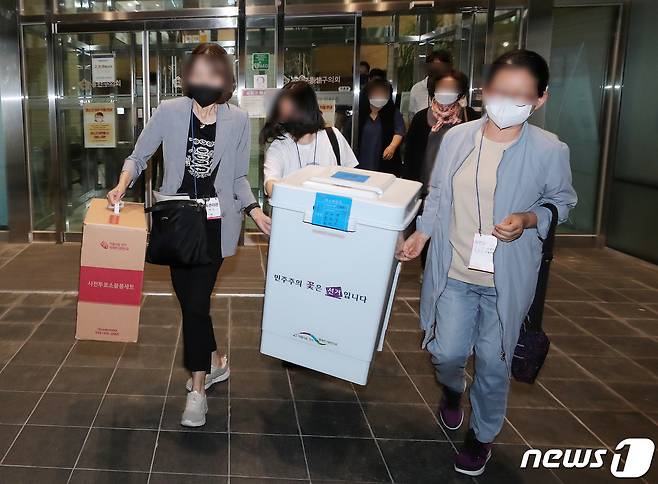 제8회 전국동시지방선거 사전 투표 이틑날인 28일 오후 서울 용산구의회에 마련된 이태원 제1동 사전투표소에서 사무원과 참관인들이 사전투표가 끝난 뒤 수거한 투표함을 이송차량으로 옮기고 있다. 중앙선거관리위원회에 따르면 27~28일 이틀간 진행된 사전투표에 전국 유권자 4430만3449명 중 913만3522명이 투표에 참여해 투표율은 20.62%를 기록했다. 2022.5.28/뉴스1 © News1 구윤성 기자