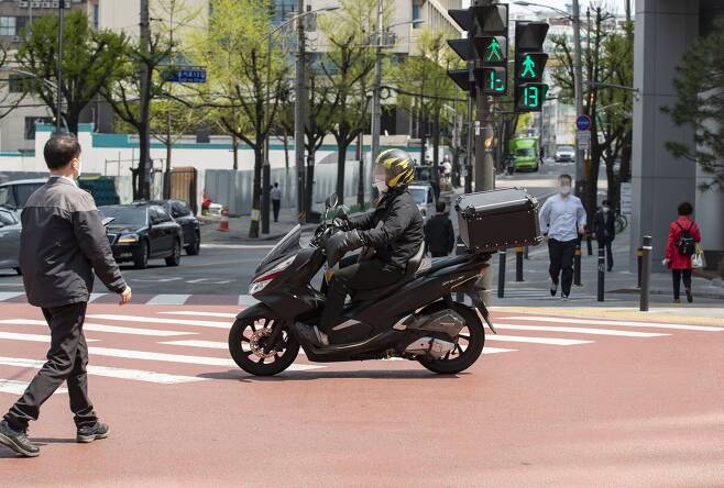 4월 12일 오후 서울 중구 거리에서 오토바이가 횡단보도를 가로질러 건너가고 있다. /조선DB