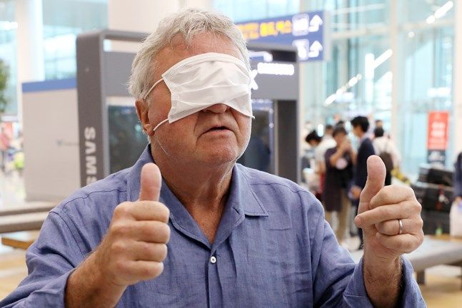 히딩크 감독이 28일 오후 인천국제공항 제2여객터미널을 통해 입국해 마스크로 얼굴을 가리며 장난스러운 포즈를 취하고 있다. ⓒ 뉴시스