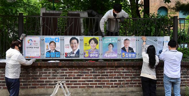 19일 서울 종로구 대학로에서 종로선관위 직원들이  제8회 전국지방선거 벽보를 설치하고 있다. [사진 = 이충우 기자]