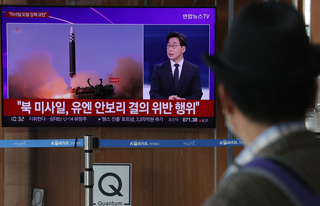 지난 25일 서울역에서 시민들이 북한 미사일 발사 관련 뉴스를 보고 있다. 연합뉴스