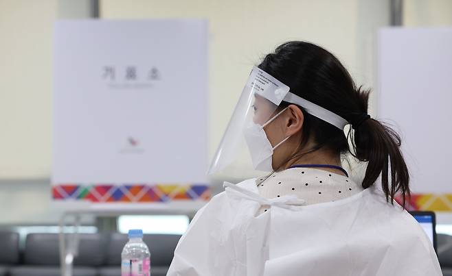 제8회 전국동시지방선거 사전투표 이틀째인 28일 서울 용산구의회에 마련된 사전투표소에서 투표사무원과 관계자들이 코로나19 확진·격리자 사전투표를 위해 방호복 등을 착용하고 있다. /연합뉴스
