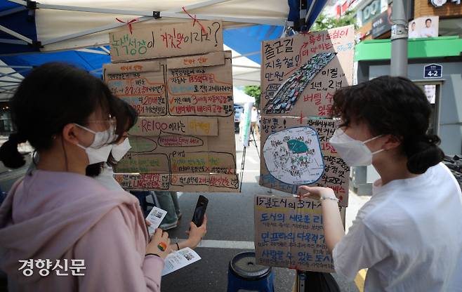 대학생기후행동 활동가(오른쪽)가 29일 서울 신촌역 인근에서 열린 ‘2022 알록달록 기후정의 페스티벌’ 참여 시민들에게 기후위기 관련 설명을 하고 있다. 권도현 기자