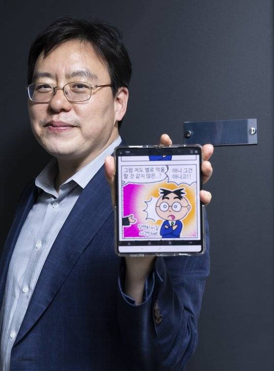 현역 만화가인 이영욱 변호사가 법률신문에 연재중인 4컷 만화 ‘변호사25시’의 한 장면을 핸드폰으로 보여주고 있다. 권혁재 사진전문기자