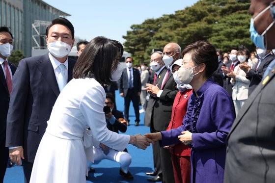 윤석열 대통령 부인 김건희 여사가 5월 10일 서울 여의도 국회 앞마당에서 열린 제20대 대통령 취임식에서 박근혜 전 대통령과 악수하고 있다. (대통령실 제공) 뉴스1