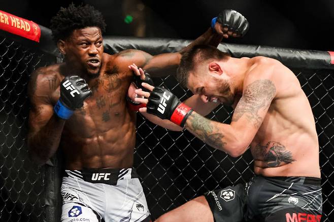 케빈 홀랜드(왼쪽)가 상대인 팀 민스를 거세게 몰아붙이고 있다. 사진=UFC