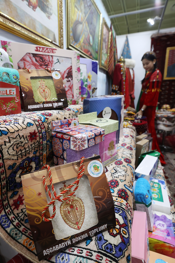 An official from the Turkmenistan Embassy arranges products displayed at the 2022 Import Goods Fair held at Coex in Gangnam District, southern Seoul, on Thursday. [YONHAP]