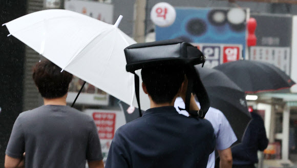 전국적인 장마 시작이 예보된 23일 오전 시민들이 서울 중구 을지로입구역 인근에서 우산을 쓰고 출근하고 있다. 2022.6.23 연합뉴스