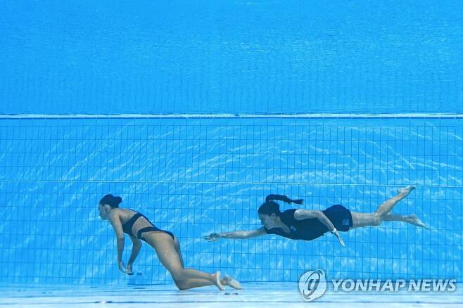수영장 바닥으로 가라앉은 아니타 알바레스(왼쪽)에게 다가가는 안드레아 푸엔테스 코치 [AFP=연합뉴스]