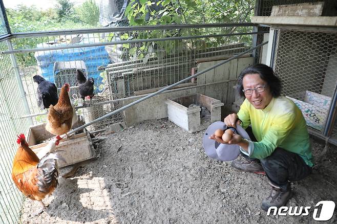 김창승씨가 갓 나은 달걀을 들고 웃음짓고 있다. © News1