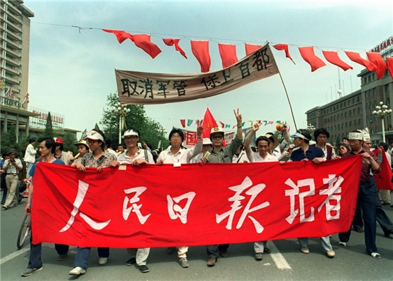 <1989년 5월 22일, 중국공산당의 대표적인 기관지 “인민밀보”의 기자단이 “군정 철폐와 수도 사수!”의 구호를 들고 가두 행진을 하고 있다. 사진/ Catherine Henriette/AFP>