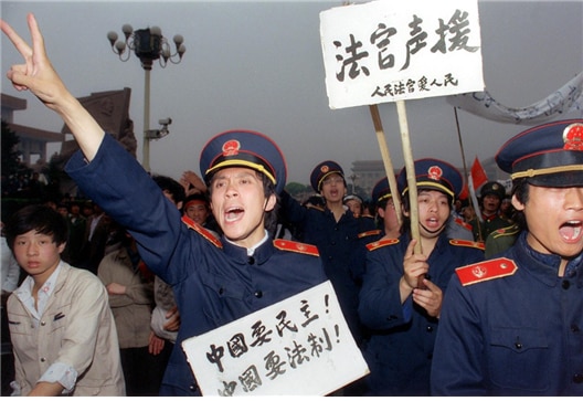 <1989년 5월 18일 법복을 입은 베이징 법원의 법관들이 “중국은 민주를 원한다! 중국은 법제를 요구한다!”, “법원은 (민주화 운동을) 성원한다!” “인민법원은 인민을 사랑한다” 등의 구호를 들고 민주화 운동에 동참하고 있다. 사진/Catherine Henriette/AFP>