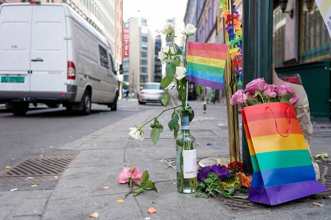 25일(현지 시각) 노르웨이 수도 오슬로에서 총기 난사 사건이 발생한 현장에 희생자를 추모하는 꽃과 깃발 등이 놓여있다. /AFP 연합뉴스