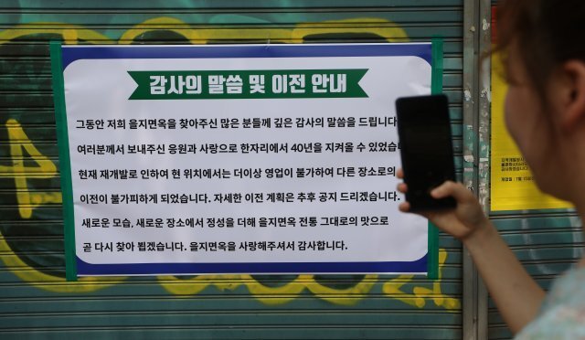 37년 전통의 서울 평양냉면 맛집인 을지면옥 영업 마지막 날인 25일 오후 서울 중구 을지면옥에서 한 소비자가 감사 인사와 이전 안내문을 보고 있다. 뉴시스