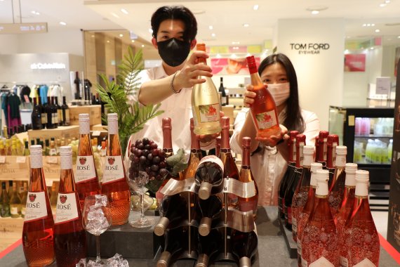 롯데백화점 대전점 지하 1층 와인매장에서 홍보도우미들이 판매중인 와인을 들어보이고 있다.
