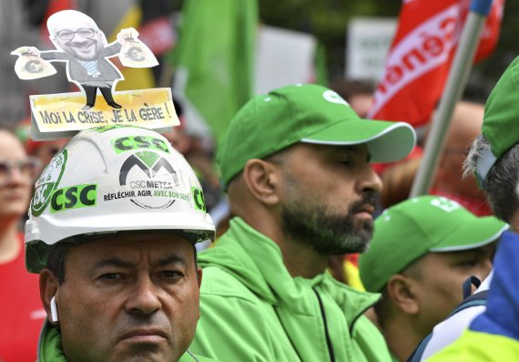 벨기에 브뤼셀에서 지난 20일(현지시간) 생활비 상승에 항의하는 대규모 시위가 열렸다. 한 남성 시위자가 돈가방을 들고 있는 샤를 미셸 유럽평의회 의장의 사진이 달린 모자를 쓰고 시위에 참가하고 있다. AP뉴시스