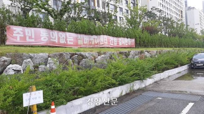 서울 송파구 가락동 481-2번지 부지. 뒤로 헬리오시티 아파트가 보인다. ‘주민동의 없는 실버케어센터 건립 결사반대’라 적힌 낡은 현수막이 남아있다. 류인하 기자