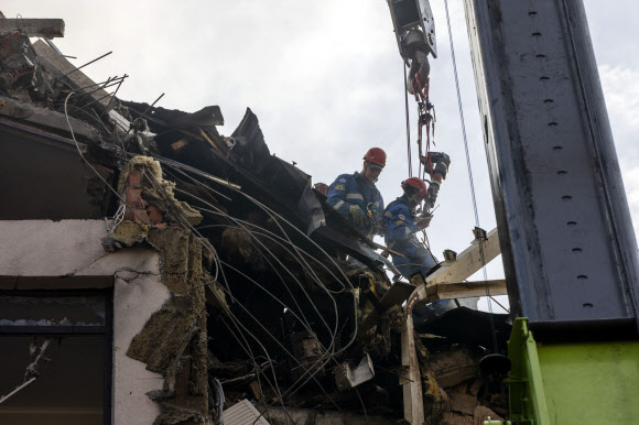우크라이나 수도 키이우에서 소방관들이 26일(현지시간) 이른 아침 폭격으로 파괴된 아파트에서 작업을 하고 있다. 2022.6.26 AP 연합뉴스