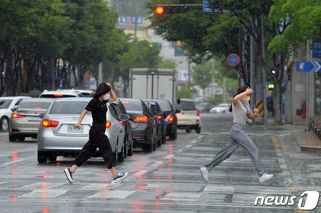 27일 오후 경북 포항시청 앞 횡단보도에서 갑자기 내린 소나기에 놀란 공무원들이 비를 피해 달리고 있다.2022.6.27/뉴스1 © News1 최창호 기자