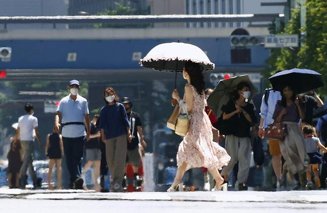 25일 낮 기온 35도가 넘는 도쿄 긴자 거리를 시민들이 걷고 있다. 도쿄/연합뉴스