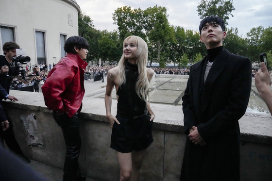 From left, V of BTS, Lisa of Blackpink and Park Bo-gum pose for photographers before the Celine men's Spring Summer 2023 collection presented in Paris on June 26. [AP/YONHAP]