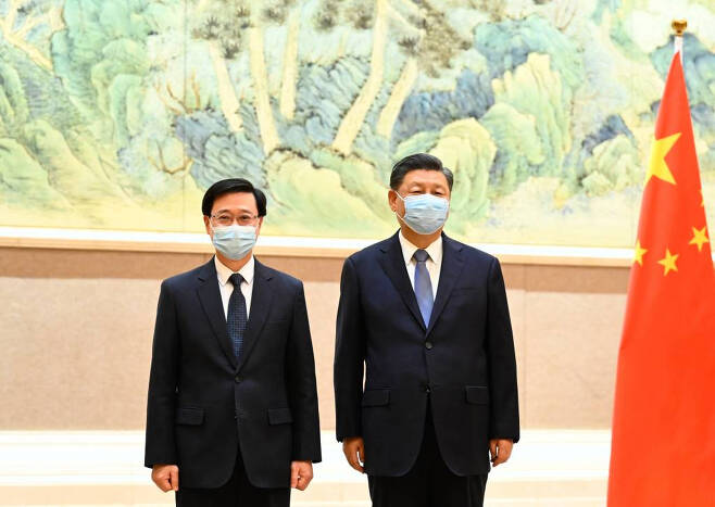 시진핑(오른쪽) 중국 국가주석이 5월 30일 베이징에서 존 리 홍콩 행정장관 당선인을 만나 기념 촬영을 하고 있다. 시 주석은 "새 행정부가 새로운 분위기를 조성해 홍콩 발전의 새로운 장을 열 것"이라며 "리 당선인이 국가 안보와 홍콩의 번영, 안정을 지키는 데 이바지하길 바란다"라고 말했다. /신화=뉴시스