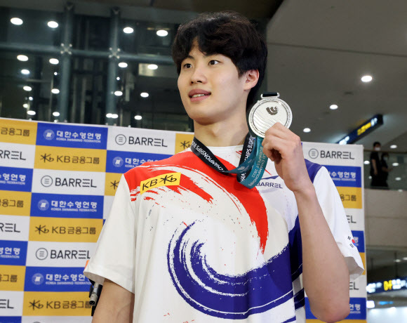 2022년 세계수영선수권 대회에서 은메달을 획득한 황선우 선수가 27일 인천국제공항 제1여객터미널로 귀국해 메달을 들어보이고 있다.연합뉴스