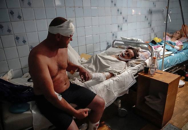 27일(현지시각) 우크라이나 중부 폴타바주 크레멘추크의 한 쇼핑센터에서 러시아의 로켓 공격으로 부상을 입은 시민들이 병원으로 옮겨져 치료받고 있다. 크레멘추크/로이터 연합뉴스