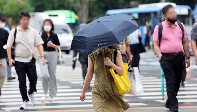 29일 오전 서울 종로구 광화문 네거리에서 시민들이 우산을 들고 출근하고 있다. 연합뉴스