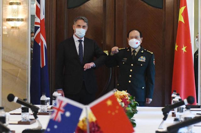 12일 싱가포르에서 열린 아시아 안보회의에서 리처드 말레스 호주 국방부 장관과 웨이펑허 중국 국방부장이 팔꿈치를 부딪치며 인사를 나누고 있다. 싱가포르=AFP 연합뉴스