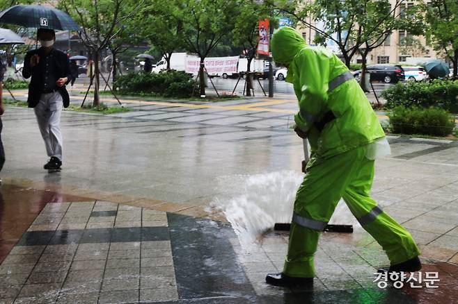 한 시민이 29일 광화문 인근 거리에 쌓인 빗물을 치우고 있다. /한수빈 기자