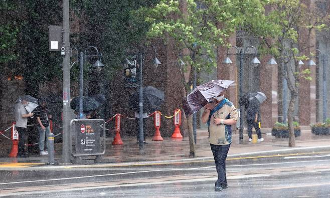 장마가 계속되는 29일 오후 서울 청계광장에서 시민들이 우산을 쓴 채 걸어가고 있다. [연합]