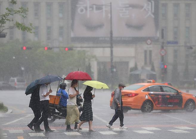 지난 29일 오후 서울도서관 인근에서 시민들이 우산을 쓴 채 횡단보도를 건너고 있다. 연합뉴스