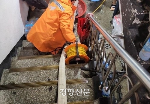 인천의 한 빌라 지하가 침수돼 소방대원들이 배수작업을 하고 있다| 연합뉴스 제공