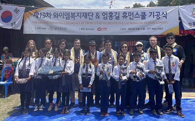 엄홍길(뒷줄 왼쪽서 다섯 번째) 엄홍길휴먼재단 상임이사가 19번째 학교 건립을 후원하는 YM복지재단 박윤순(〃여섯 번째) 회장, 네팔 정부 관계자 등이 참석한 가운데 지난달 27일 네팔 테라툼 아뜨라이에서 기공식을 갖고 있다. 엄홍길휴먼재단 제공