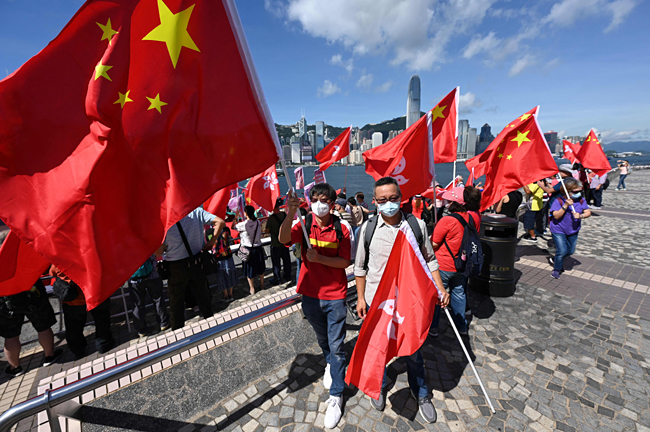 홍콩 반환 25주년을 앞둔 지난 28일 홍콩 빅토리아항에서 시민들이 중국 오성홍기와 홍콩 국기를 들고 있다. AFP연합뉴스